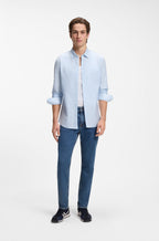 Camisa BOSS Slim Fit para homem com padrão às riscas azuis, combinada num look casual contemporâneo.
