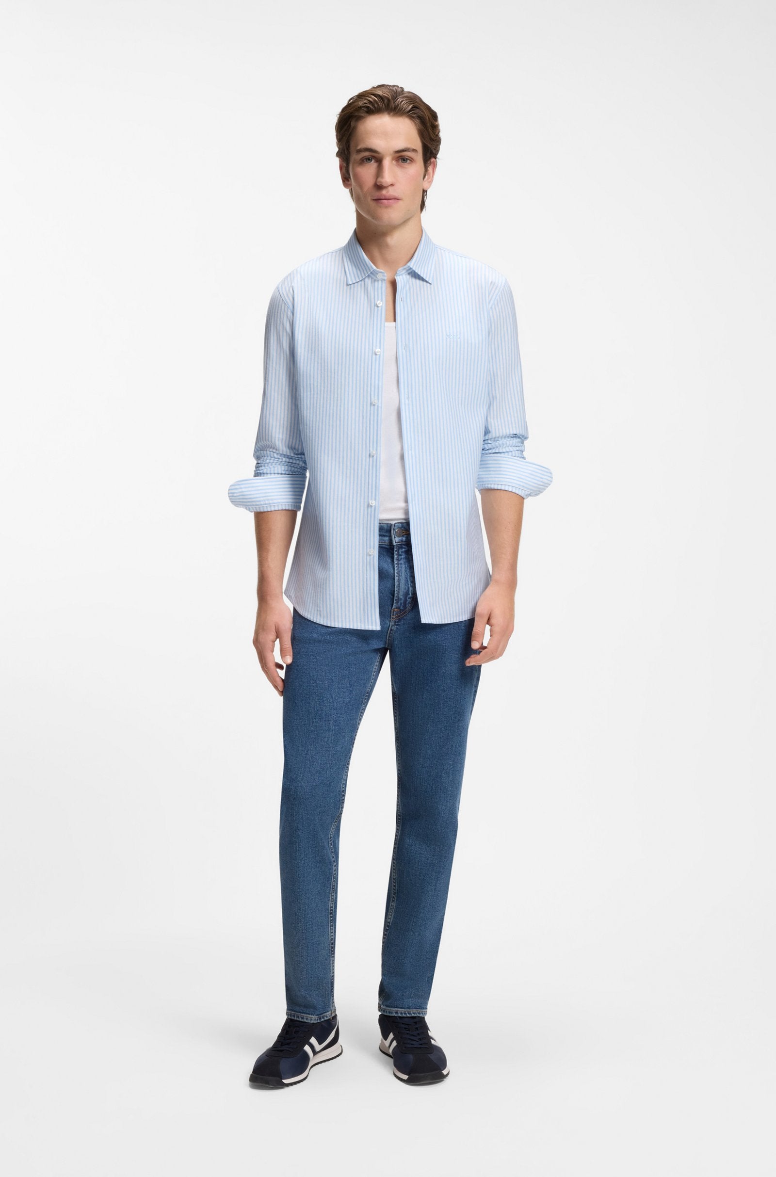 Camisa BOSS Slim Fit para homem com padrão às riscas azuis, combinada num look casual contemporâneo.
