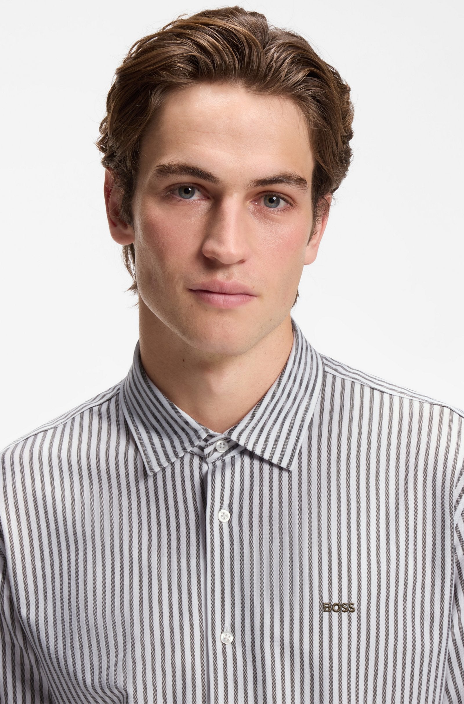 Detalhe do colarinho, botões e logótipo BOSS da camisa Slim Fit riscas verdes para homem em jersey de mistura de algodão.