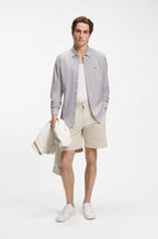 Camisa BOSS Slim Fit para homem com padrão às riscas verdes, combinada num look casual contemporâneo.