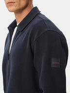 Vista lateral do casaco BOSS Ze_Bend Regular Fit azul-marinho para homem, destacando o logótipo BOSS aplicado na manga.