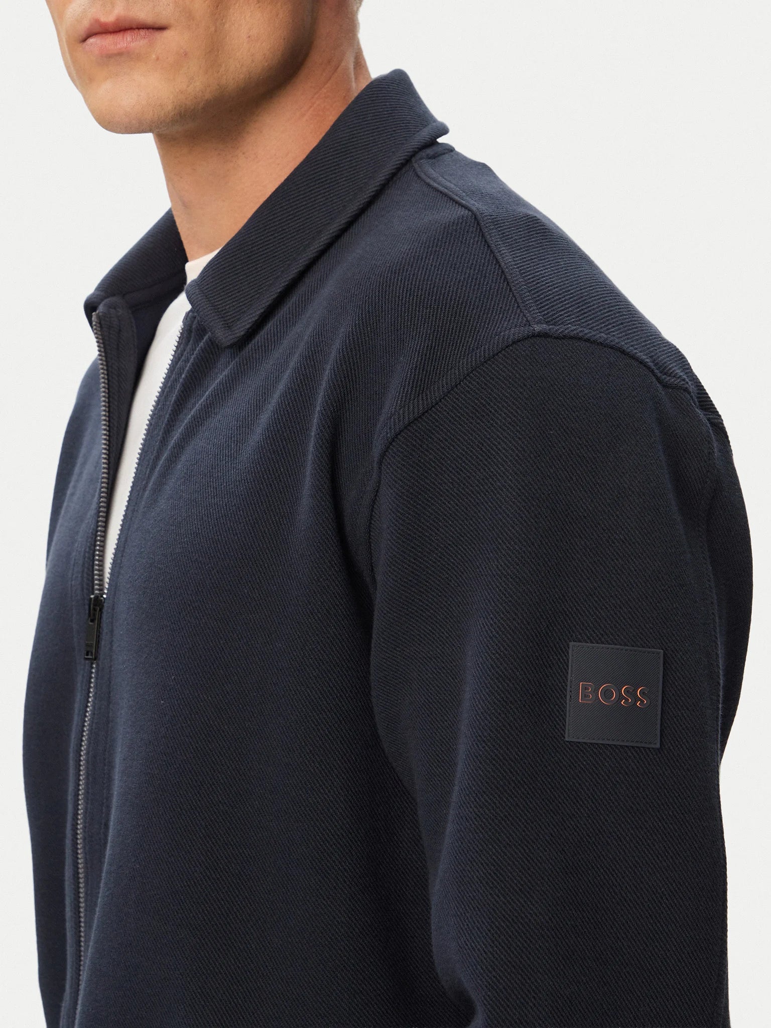 Vista lateral do casaco BOSS Ze_Bend Regular Fit azul-marinho para homem, destacando o logótipo BOSS aplicado na manga.