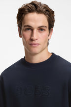 Pormenor da gola redonda e do logótipo BOSS em relevo na sweatshirt azul-marinho para homem em algodão premium.