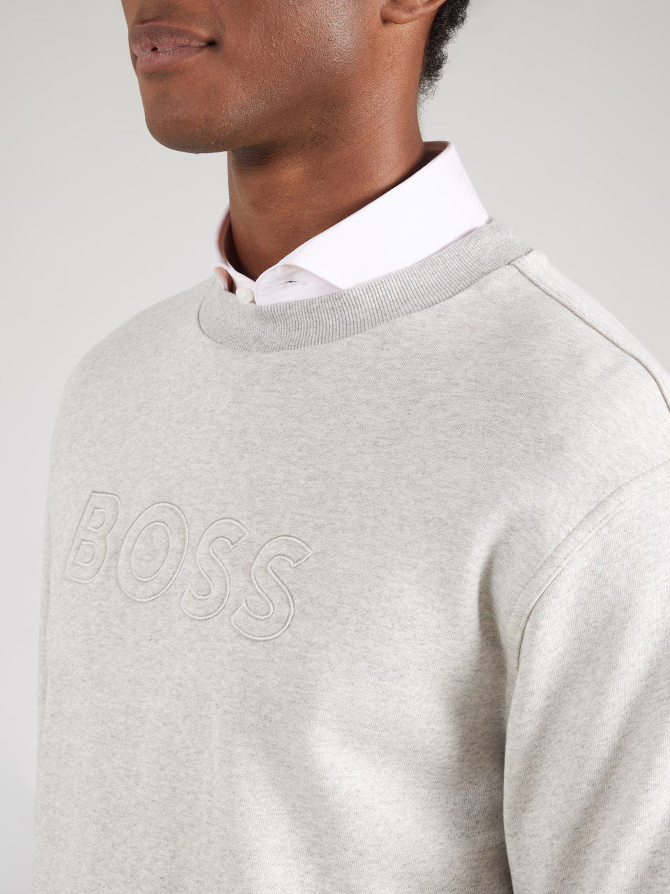 Pormenor da gola redonda e do logótipo BOSS em relevo na sweatshirt cinzento  para homem em algodão premium.