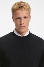 Pormenor da gola redonda e do logótipo BOSS em relevo na sweatshirt preto para homem em algodão premium.