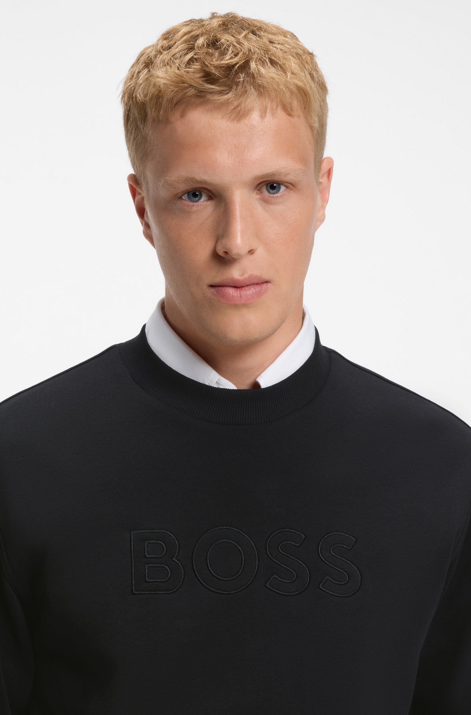Pormenor da gola redonda e do logótipo BOSS em relevo na sweatshirt preto para homem em algodão premium.