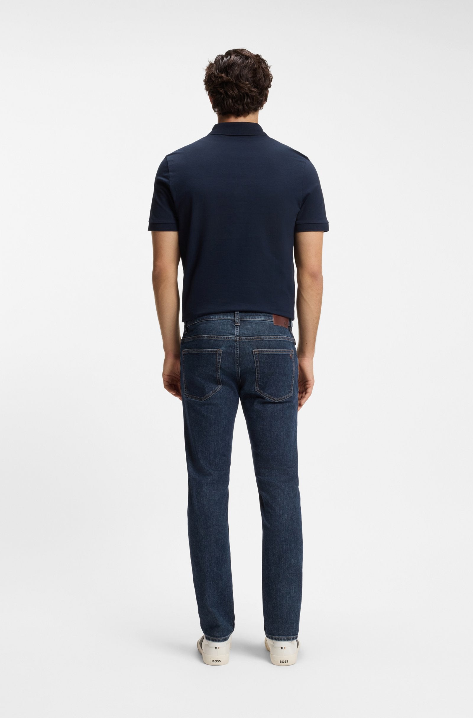 Vista traseira das jeans Delaware para homem em ganga elástica azul-escura, com corte moderno e design de cinco bolsos.