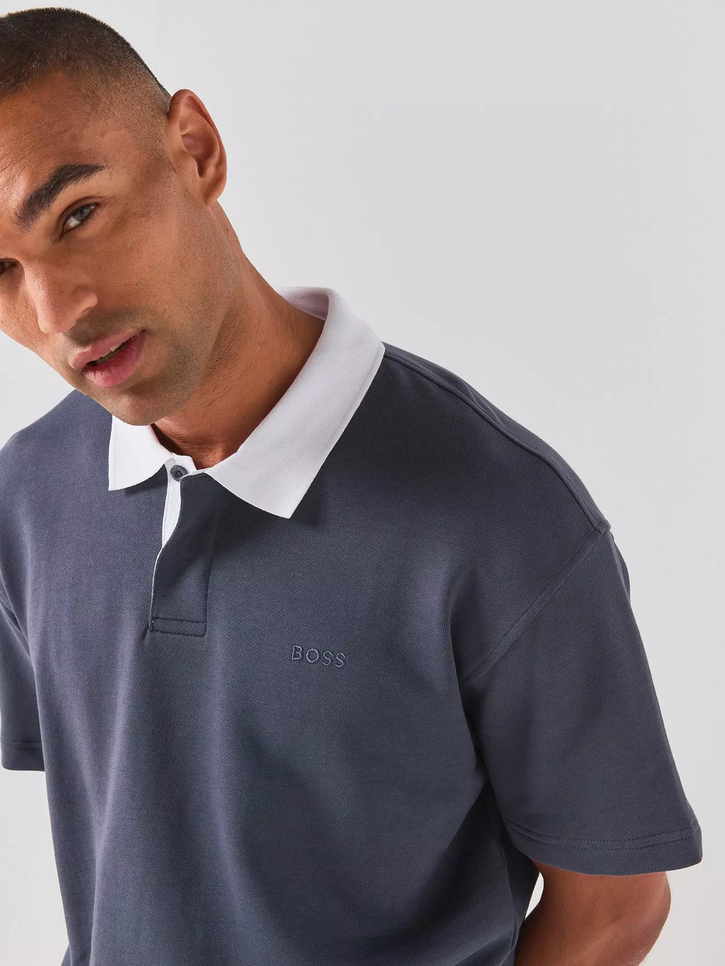 Detalhes aproximados do polo BOSS para homem em jersey de algodão azul-escuro, destacando a gola branca em contraste, o acabamento premium.