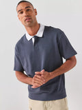 Vista frontal do polo para homem BOSS azul-escuro de manga curta, com gola branca em contraste, carcela de dpois botões, logótipo BOSS bordado no peito, acabamento canelado na cintura, tecido macio de elevada qualidade e corte regular para um visual casual elegante e contemporâneo.