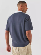 Vista traseira do polo BOSS para homem em jersey de algodão azul-escuro, evidenciando o caimento regular, o corte elegante e os acabamentos premium nas costas.
