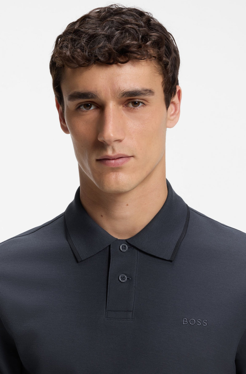 Pormenor do polo Phoenix azul marinho para homem em algodão mercerizado da B0SS, destacando o tecido piqué, a gola clássica, a carcela com dois botões e o logótipo BOSS bordado no peito.