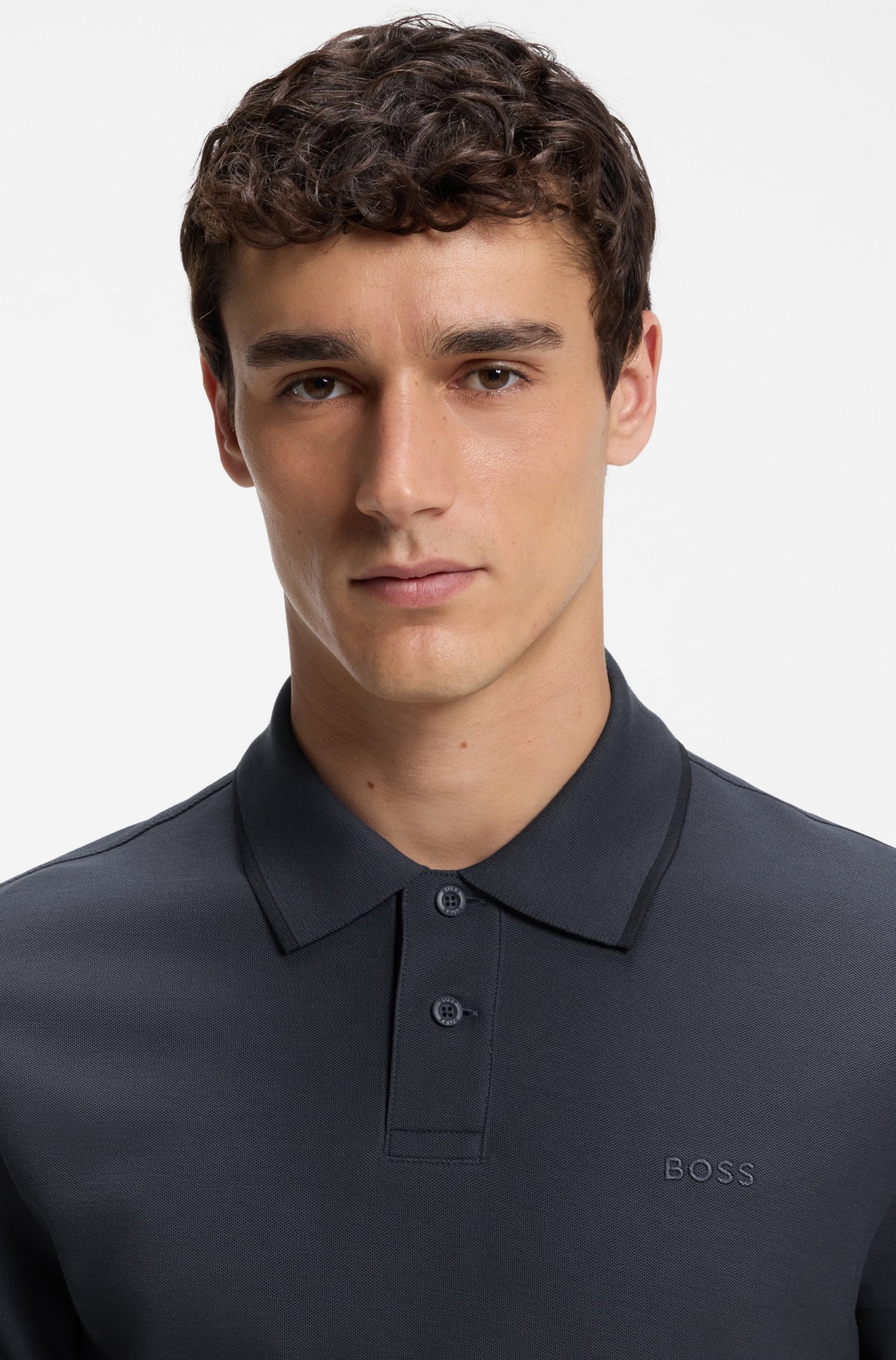 Pormenor do polo Phoenix azul marinho para homem em algodão mercerizado da B0SS, destacando o tecido piqué, a gola clássica, a carcela com dois botões e o logótipo BOSS bordado no peito.