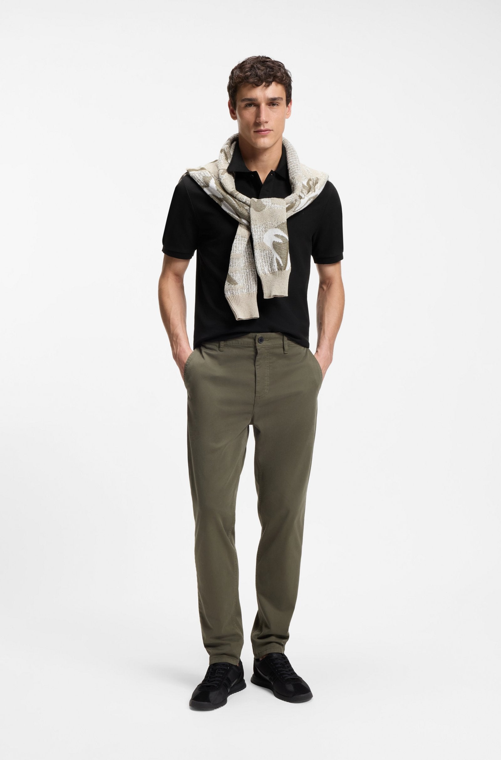 Polo Phoenix preto para homem da BOSS em algodão mercerizado com tecido piqué, corte regular e logótipo bordado, apresentado em modelo num look casual elegante.