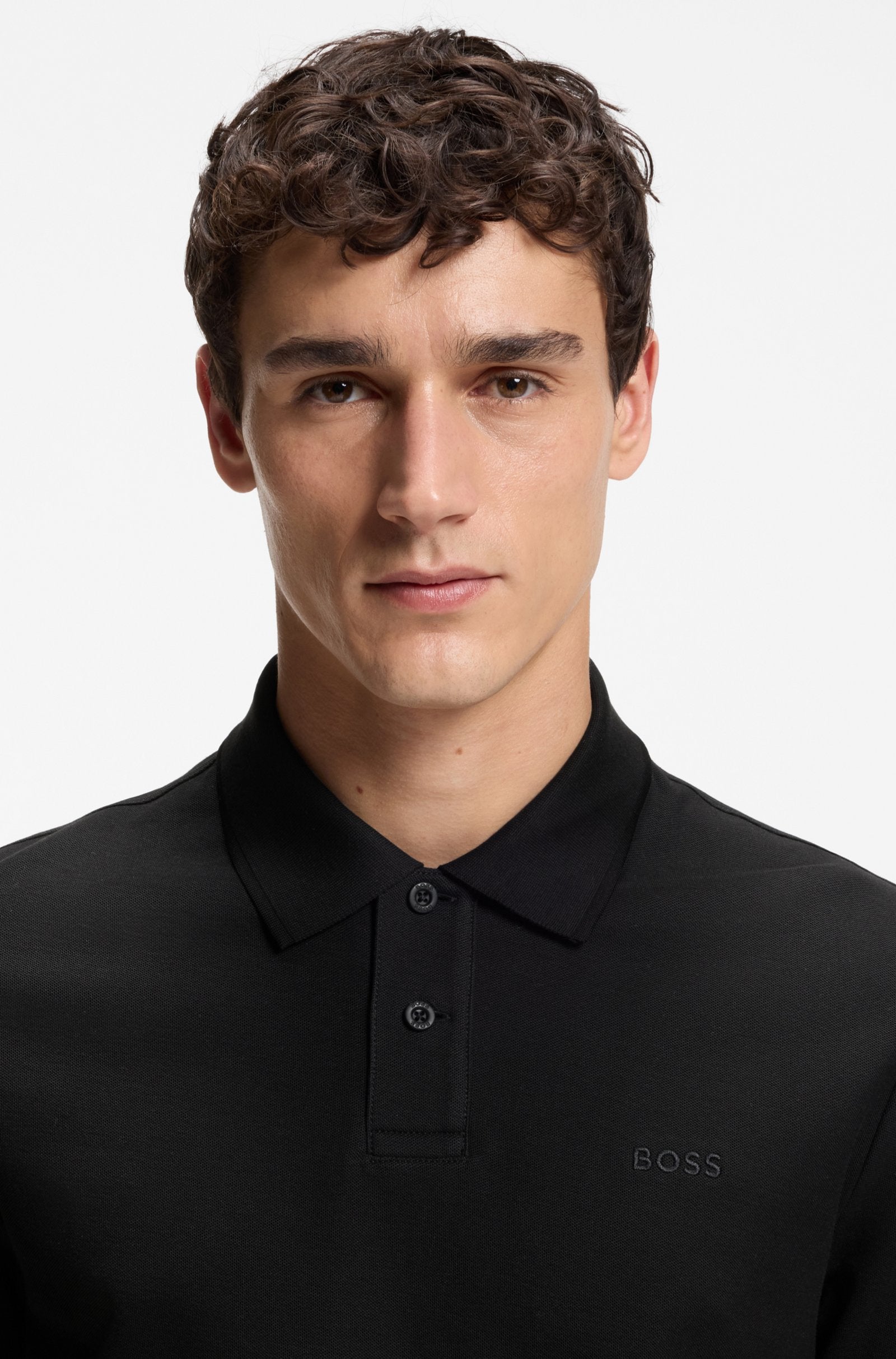Pormenor do polo Phoenix preto para homem em algodão mercerizado da B0SS, destacando o tecido piqué, a gola clássica, a carcela com dois botões e o logótipo BOSS bordado no peito.