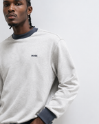 Detalhes da sweatshirt BOSS cinza para homem com logótipo BOSS bordado no peito e detalhes contrastantes na gola e nos punhos.