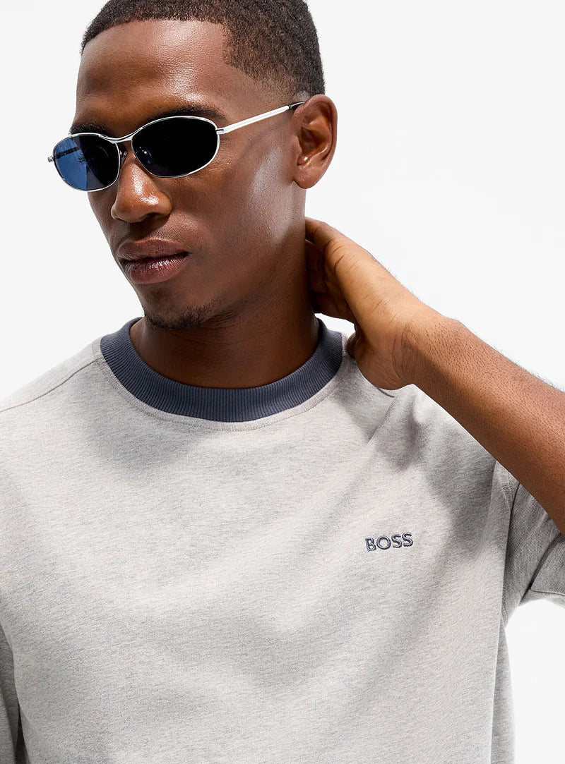 Detalhe da t-shirt cinza claro para homem da Boss com logótipo bordado no peito e gola redonda em contraste. 