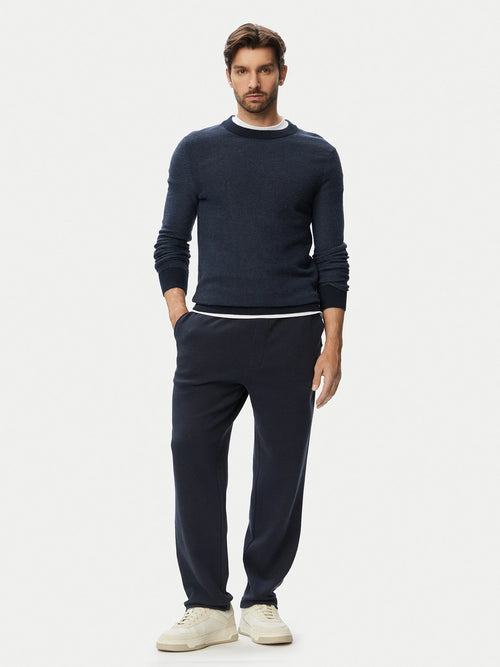 Modelo com calças BOSS Regular Fit azul-marinho para homem em algodão elástico, combinadas num look casual elegante.