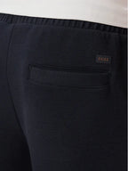 Pormenor do bolso traseiro das calças BOSS SE Bend Regular Fit azul-marinho em algodão elástico com logótipo BOSS e acabamento premium.