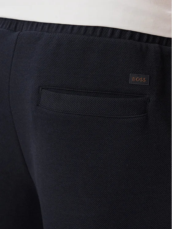 Pormenor do bolso traseiro das calças BOSS SE Bend Regular Fit azul-marinho em algodão elástico com logótipo BOSS e acabamento premium.