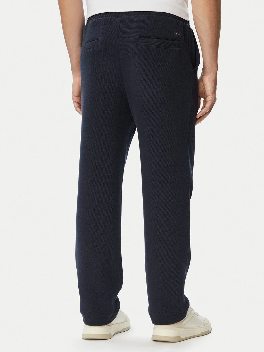 Vista traseira das calças BOSS Regular Fit azul-marinho para homem em algodão elástico com bolsos traseiros e corte confortável.