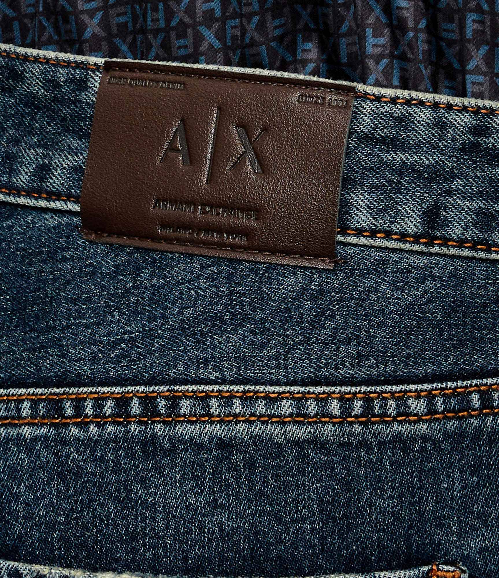 Detalhe da etiqueta em pele com assinatura Armani Exchange nas jeans J13 Comfort Slim. 