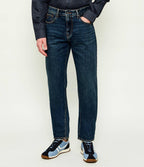 Caimento das jeans J13 Comfort Slim Armani Exchange em denim azul apresentadas no modelo. 