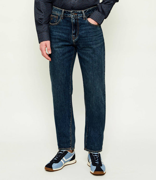 Caimento das jeans J13 Comfort Slim Armani Exchange em denim azul apresentadas no modelo. 